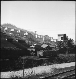 USA, Scotts Run/WV: Häuser; Häuser an einem Hang, davor Eisenbahnwagen und eine Abladestelle für Kohle