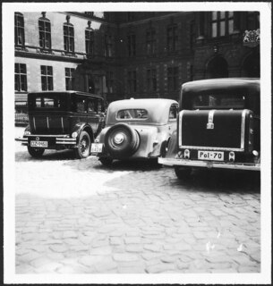 [...] | 14) Drei Wagen, -Nummernschilder dreier Länder: Polen, Deutschland, Freistaat Danzig. Dieses Bild illustriert treffend die klassische geographische und die aktuelle Lage des Hafens an der Weichselmündung. | [...] | [maschinengeschriebener Eintrag auf separatem Beiblatt][...] | Three cars in Danzig, three tags, three countries: Danzig, Germany, Poland. | [...] | [maschinengeschriebener Eintrag auf separatem Beiblatt]9