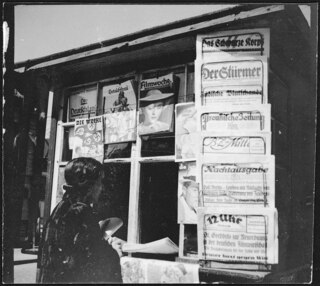 [...] The newspaper stand shows that Danzig has adapted the censor- | ship of the Third Reich: no others than German newspapers are allowed, | although Danzig supposedly is still a "free state". | [...] | [maschinengeschriebener Eintrag auf separatem Beiblatt; Titel: "Photos Annemarie Clark-Schwarzenbach / Danzig 1937 - Gdynia"; versehen mit Stempel: Credit: / from BLACKSTAR / GRAYBAR BUILDING NEW YORK)]A DANZIG [sic!] newspaper stand. In spite of Danzing being a "free state" one can | find no other than Nazi-German newspapers. As in the Third Reich the press | is stric[durchgestrichener Buchstabe: k]tly controlled by the Nazi party. | [maschinengeschriebener Eintrag auf separatem Beiblatt; ohne Titel]