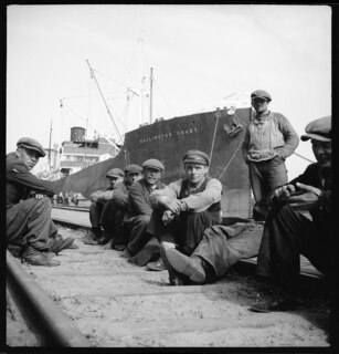 Ostpreussen, Danzig (Gdansk) oder Gdynia (Gdingen): Hafenarbeiter; Hafenarbeiter (sitzend auf Eisenbahnschienen); im Hintergrund Schiff ("Dallington Court")
