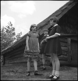 Lettland: Menschen; Mädchen vor einem Haus