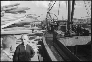 Lettland, Riga: Menschen; Zwei Jungen vor einem Stapel Holz, daneben ein Boot