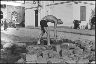 Lettland, Riga: Menschen; Ein Mann beim Einsetzen von Pflastersteinen