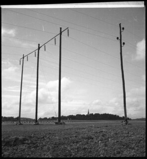 Schweden: Landschaft; Strommasten, im Hintergrund Felder und ein Dorf