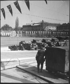 Österreich, Wien: Menschen; Im Vordergrund ein Mann in Uniform und Armeefahrzeuge, im Hintergrund Tennisplätze