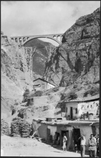 Iran, Firuzkuh (Firuz Kuh, Firouzkouh): Landschaft; Eine Brücke zwischen zwei Felsen, unten im Tal ein Dorf