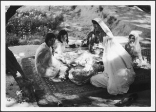 The palaw (rice meal) in the women's garden of the maire at Kaisar, Afghanistan. | - They eat on a carpet, using their fingers.