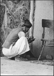 Afghanistan, Andkhoi (Andkhoy, Andkhvoy): Menschen; Ein Mann knieend vor einer Mauer