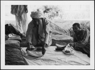 Afghanistan, Shibargan (Scheberghan, Shebergan): Menschen; Zwei Männer auf einer Decke mit Teller voller Früchte