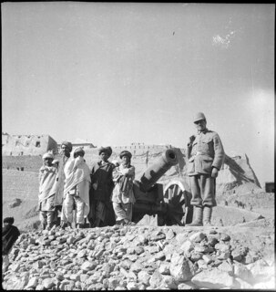 Afghanistan, Ghazni (Ghazna): Menschen; Männer, davon einer in Uniform, neben einer Kanone, im Hintergrund die Zitadelle