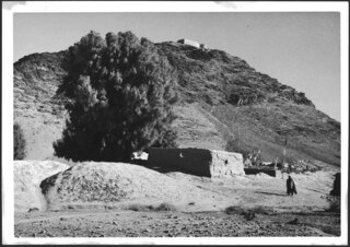 Afghanistan, zum Khyber Pass (Chaiber-Pass, Khaiberpass): Landschaft; Ein flaches Gebäude im Vordergrund, auf der Anhöhe weitere Gebäude