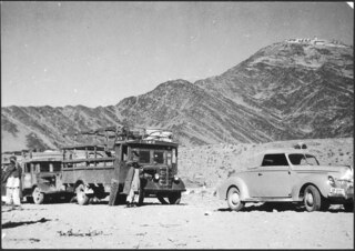 Afghanistan, Dakka (Loe Dakka): Landschaft; Der Ford in einer Reihe mit Lastwagen, auf der Anhöhe im Hintergrund Gebäude