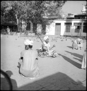 Britisch-Indien, Amritsar: Menschen; Ein sitzender Mann mit einem Musikinstrument auf einem Platz