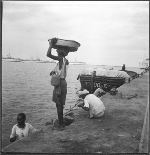 Italienisch-Ostafrika, Massana (Massawa, Massaua): Hafen; Männer an einem Quai, im Hintergrund Boote und Schiffe
