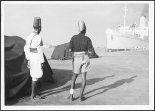 Italienisch-Ostafrika, Massana (Massawa, Massaua): Hafen; Zwei Männer in Uniform am Quai vor dem Schiff