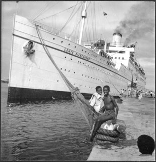 Italienisch-Ostafrika, Massana (Massawa, Massaua): Hafen; Zwei Knaben sitzend auf einem Poller, an den die Conte Biancamano angeleint ist