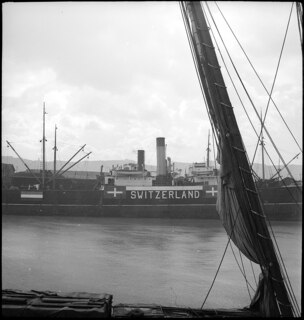 Der jugoslawische Dampfer "Dubac" im Hafen von Lissabon trägt in frischer Farbe die Insignien der Schweiz. Er gehört zu den neu gemieteten Schiffen, die die griechischen Schiffe der "Schweizer Flotte" ersetzen. | [Legende in Zeitungsartikel AS-E-256]
