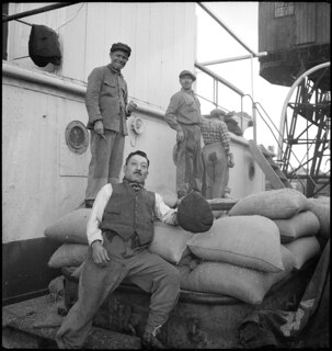 Portugal, Lissabon (Lisboa): Hafen; Arbeiter mit Säcken neben einem Schiff, in Hintergrund ein Kran