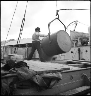 Portugal, Lissabon (Lisboa): Hafen; Ein Mann lädt aus einem Behälter, der an einem Kran hängt, Ware in ein Schiff