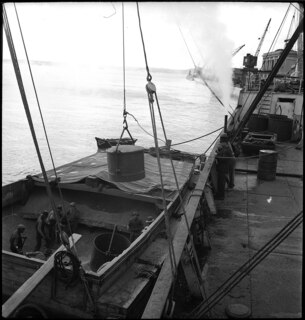 Portugal, Lissabon (Lisboa): Schiff Nereus; Arbeiter auf einem kleineren Boot entladen ein Schiff