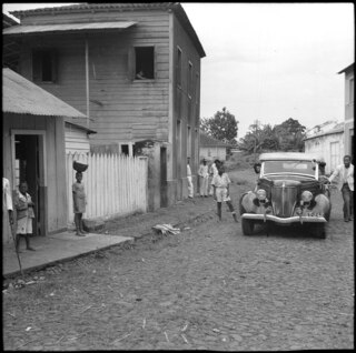 Portugal, San Thomé (São Tomé und Príncipe): Strassenszene; Häuserzeile mit Automobil und Menschen