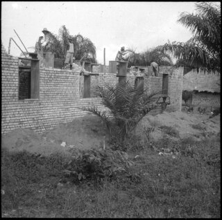 Belgisch-Kongo, Molanda (Malanda): Alltagsszene; Mehrere farbige Arbeiter bauen ein Haus