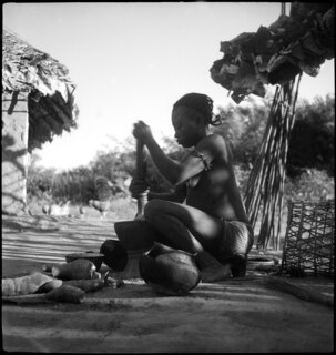 Negerfrau beim Maniokstampfen | [handschriftlicher Eintrag auf separatem Umschlag]Zerstampfen von Maniok im Mörser. | [handschriftlicher Eintrag auf Karteikarte]24