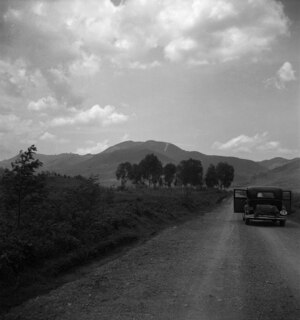 Belgisch-Kongo, Lubero: Landschaft; Chrysler steht mit offenen Türen auf einer Landstrasse mit Hügellandschaft im Hintergrund
