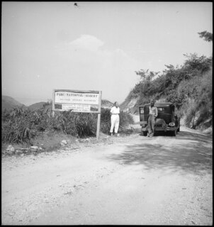 Belgisch-Kongo, Parc National Albert (Parc National des Virunga): Landschaft; Ami Vivien und ein farbiger Mann stehen neben dem Chrysler am Eingang zum Parc National Albert