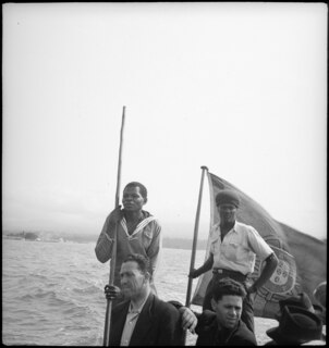 Belgisch-Kongo, Fluss Kongo: Menschen; Zwei Portugiesen und mehrere farbige Männer auf einem Boot mit portugiesischer Flagge auf dem Kongo
