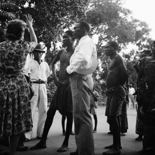 Belgisch-Kongo, Leopoldville (Kinshasa): Menschen; Mehrere farbige Männer stehen zusammen mit einer weissen Frau auf einer Strasse