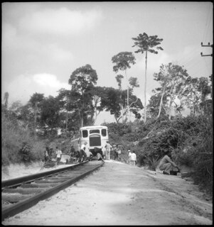 Belgisch-Kongo, Thysville (Mbanza Ngungu): Landschaft; Stehender Zug auf der Bahnstrecke Thysville - Brazzaville, umgeben von mehreren Personen die am Zug hantieren