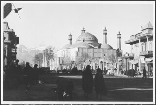 Persien, Teheran: Moschee; Eine Häuserreihe an einer Strasse, im Hintergrund eine Moschee