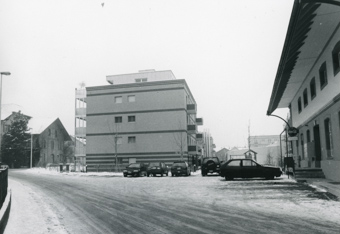 Wohnblock im Winter, daneben ein Parkplatz, gehört zu Dossier: Brauerei Baumberger
