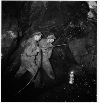 Zwei Männer bei der Arbeit mit Bohrmaschine im Berg