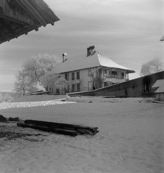 Bauernhaus mit Holzdach, Tenneinfahrt. Daneben  zweistöckiges herrschaftliches Haus. Winterliche Aufnahme mit Schnee