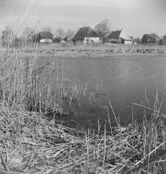 Bäuerliche Siedlung am Ufer eines Teichs 