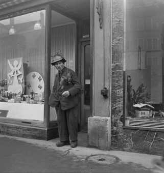 Mann mit Hut und Tannenzweigen vor weihnächtlichem Schaufenster, Waisenhausplatz Bern