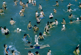 Zahlreiche Badende im Wasser stehend oder schwimmend