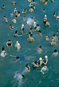 Zahlreiche Badende im Wasser stehend oder schwimmend
