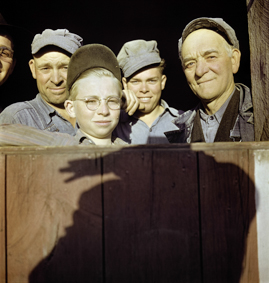 Gruppenfoto einer Bauernfamilie, an der Holztüre der Schatten von Paul Senn