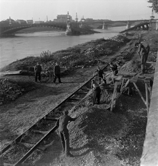 Deutsche Soldaten beim Schaufeln von Kies, Schienen einer Transportbahn, hinten die zerstörte Pont Gallieni (anderer Name: Pont du Midi) und der Viaduc du Perrache (Eisenbahnbrücke)