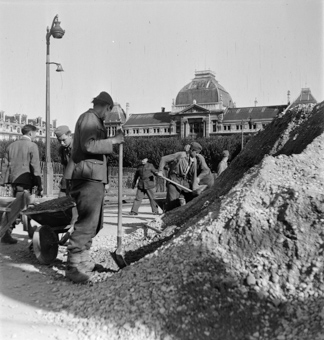 Deutsche Soldaten mit Schaufeln und Schubkarren, im Hintergrund die Universität Lyon III (Université Jean Moulin)
