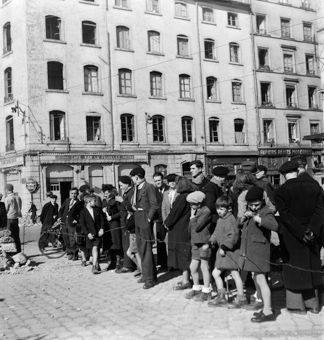 Menschengruppe hinter Absperrung: es gibt etwas zu sehen