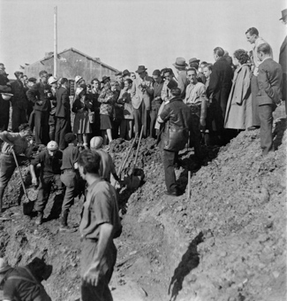 Rotkreuzfreiwillige und Soldaten bei Ausgrabungsarbeiten, Angehörige und Journalisten