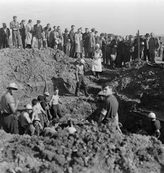 Rotkreuzfreiwillige und Soldaten bei Ausgrabungsarbeiten, Angehörige und Journalisten