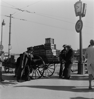 Männer am Ziehen und Stossen eines Pferde-Wagens, rechts die Pont Lafayette, Pfosten mit Uhr und Verkehrsschild, links ein Wegweiser nach Aix-les-Bains
