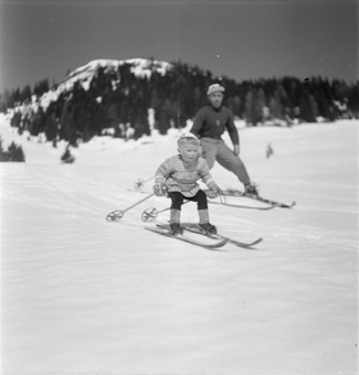 Kind und Skilehrer nebeneinander in Fahrt