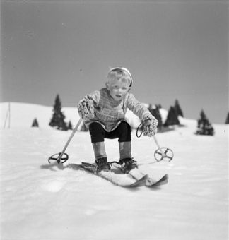 Kind auf Skiern in der Hocke