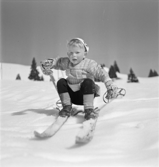 Kind auf Skiern in tiefer Hocke